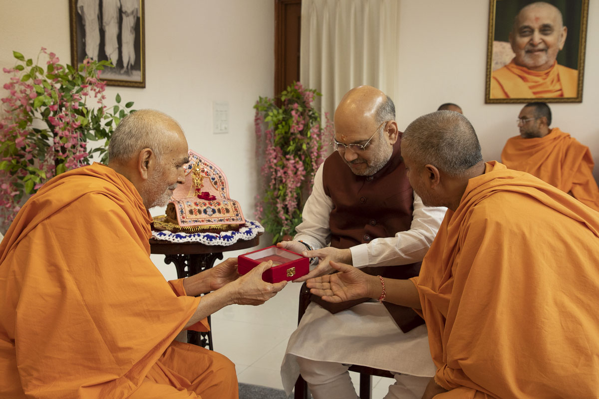 Swamishri presents a holy relic in memory of Pramukh Swami Maharaj to Shri Amit Shah