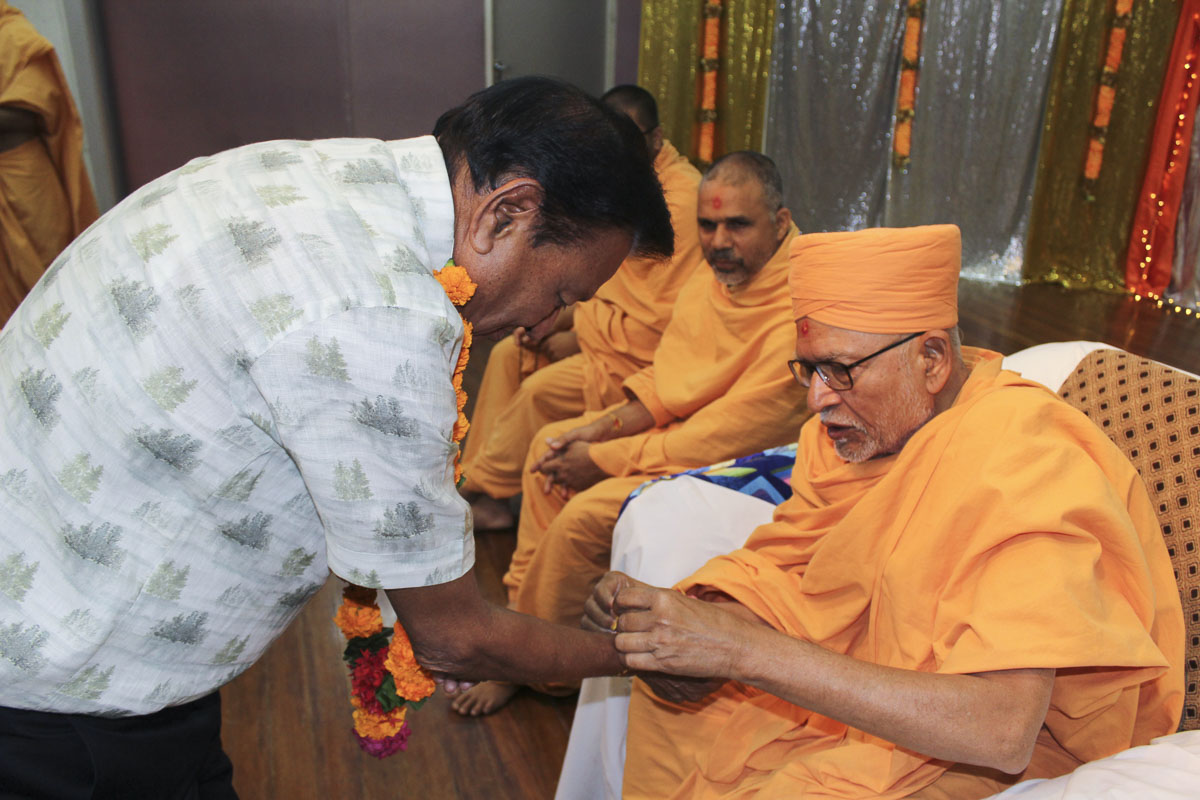 Pujya Kothari Swami ties nadachhadi to a devotee