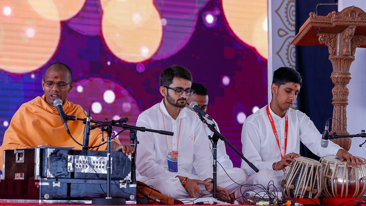 Sadhus and karyakars sing kirtans in morning session of the shibir