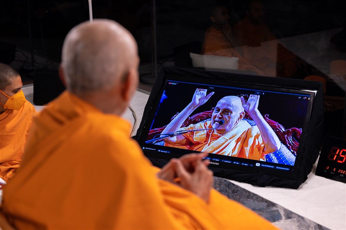 Swamishri watches a smruti video of Pramukh Swami Maharaj in London from 2006