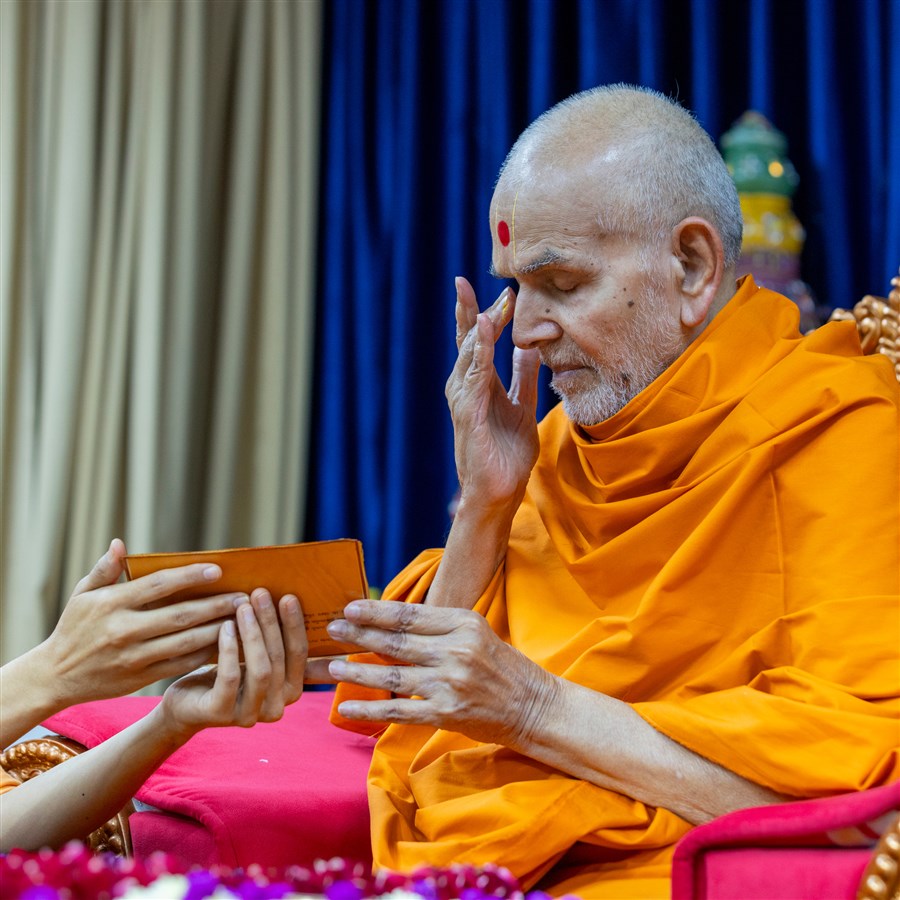 Swamishri reverently touches his eyes after touching the holy feet of Shri Akshar-Purushottam Maharaj
