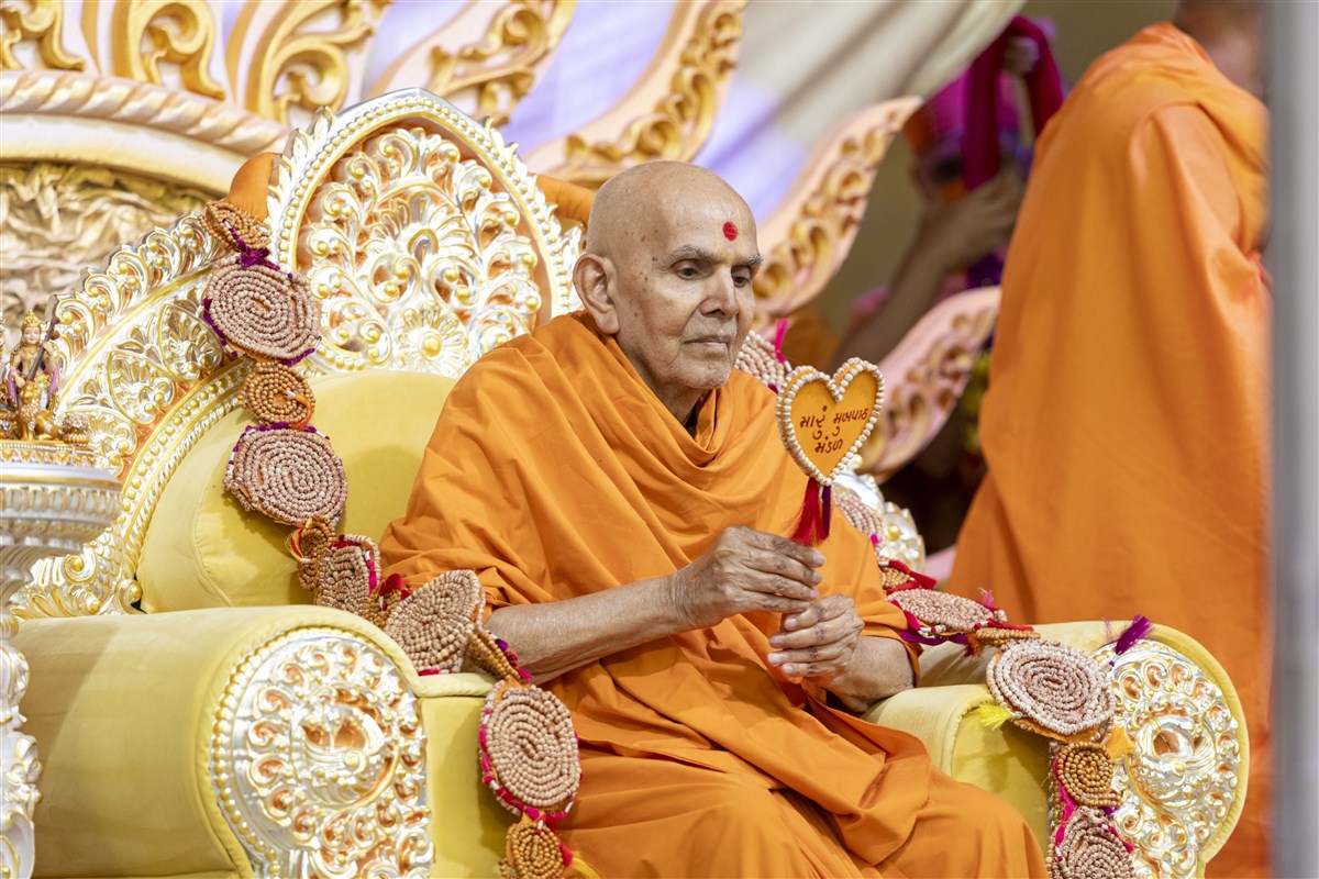 Swamishri honored with a garland and a chhadi